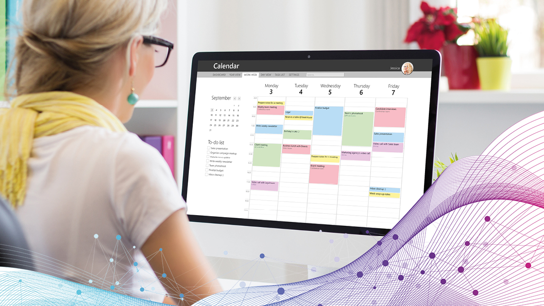 Frau schaut auf ihren Laptop-Bildschirm, auf dem ein Kalender geöffnet ist