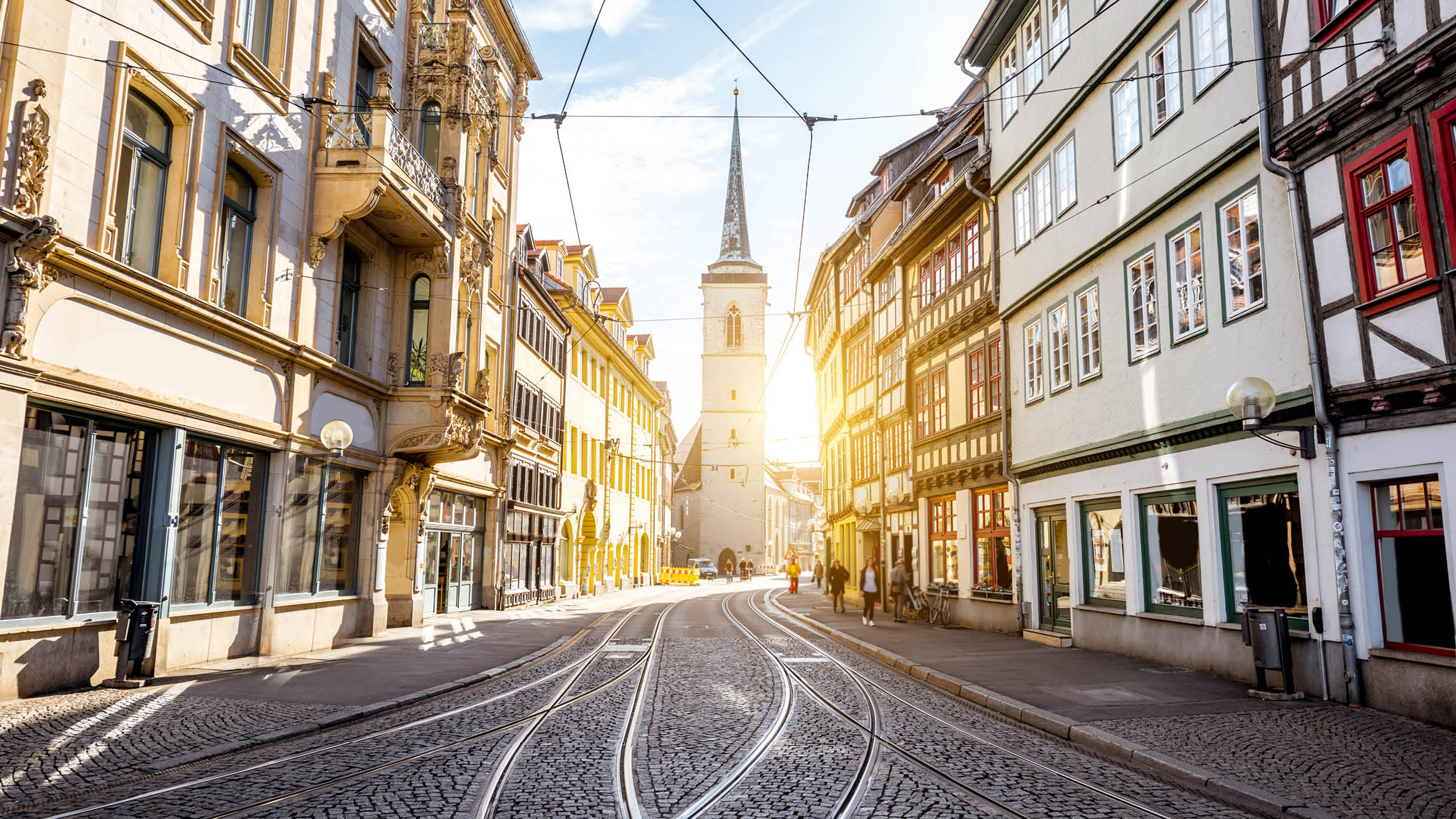 Stadt Erfurt mit Dom im Sonnenlicht und Straße mit Schienen