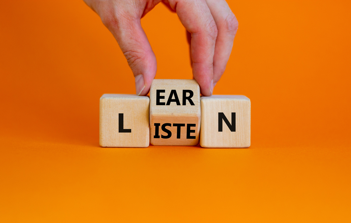 Würfel auf orangefarbenem Hintergrund mit dem Text „LEARN“ darauf