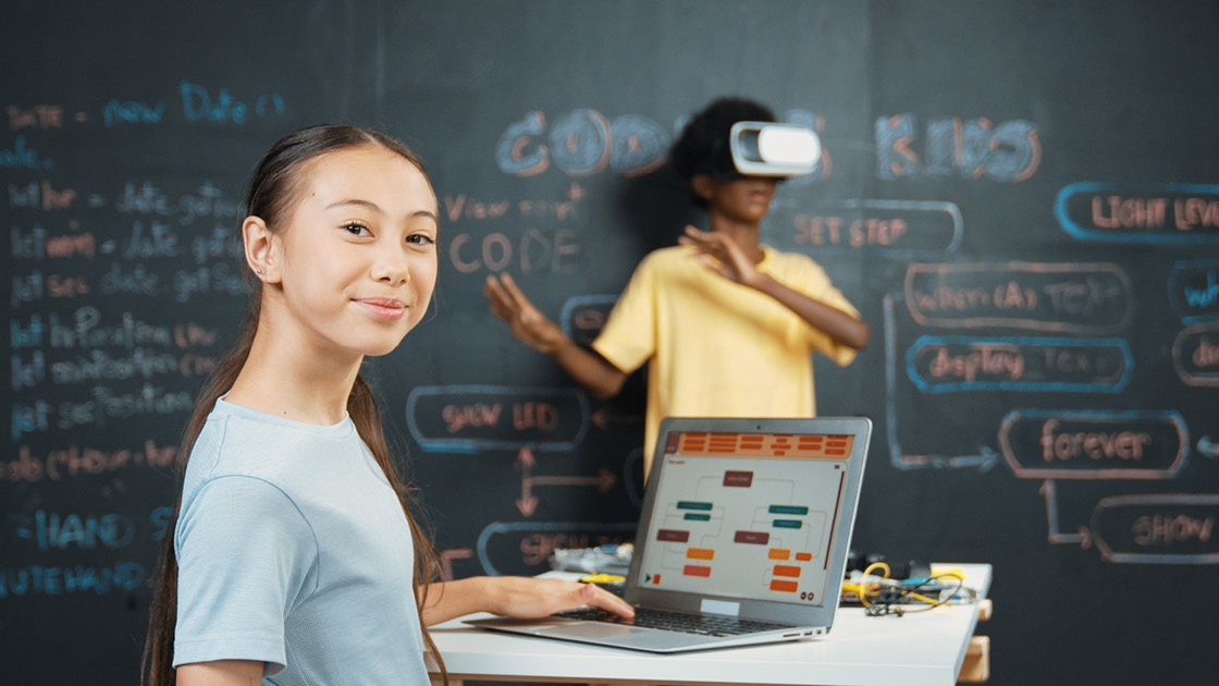 Schülerin am Laptop und Schüler mit VR-Brille Schülerin am Laptop und Schüler mit VR-Brille
