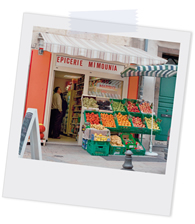 Polaroidfoto, das Obst- und Gemüsestände eines Ladens im Freien und Personen im Inneren des Ladens zeigt