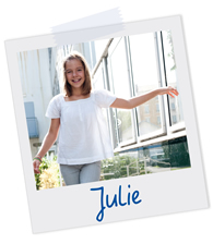 Polaroidfoto eines Mädchens, das lächelnd in die Kamera schaut, mit der Beschriftung „Julie”